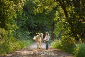 High School Senior Girl walking with Horse