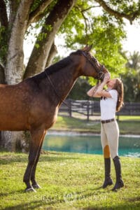 Portrait of a woman kissing her horse